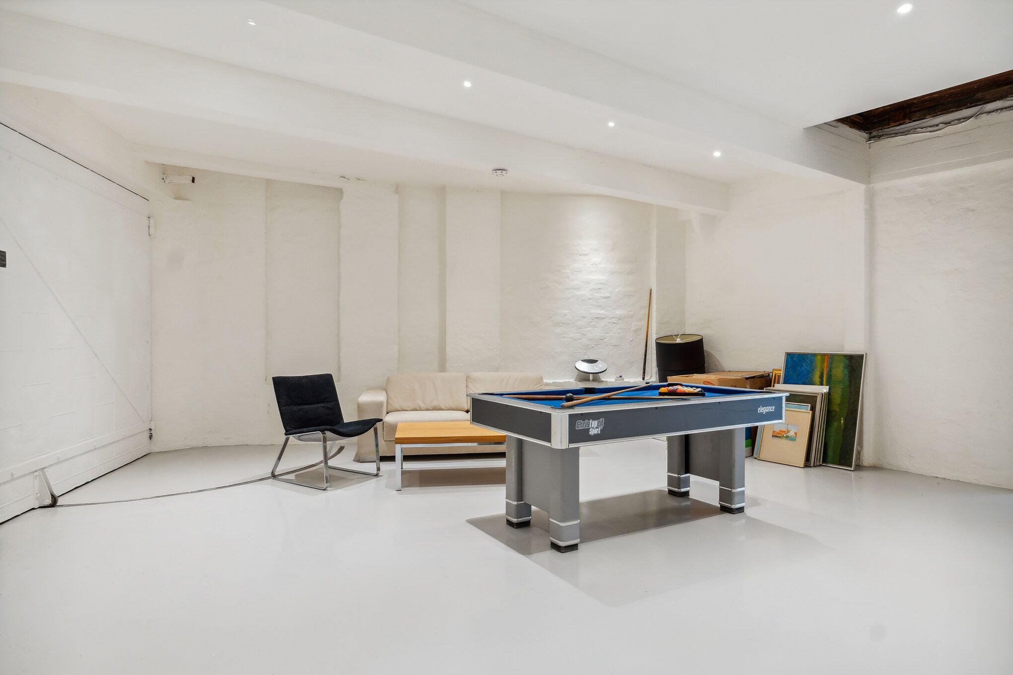 Velegnet til kreativt kontor eller værksted med poolbord, sofa og kunstværker. Elegant poolbord og møbler. Forskellige
