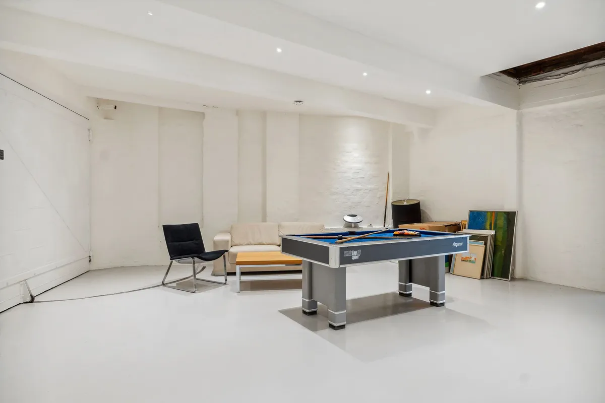 Velegnet til kreativt kontor eller værksted med poolbord, sofa og kunstværker. Elegant poolbord og møbler. Forskellige