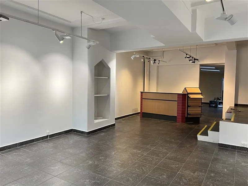 Lokale med højt til loftet, lysekroner og et stort åbent rum med gulvbelægning