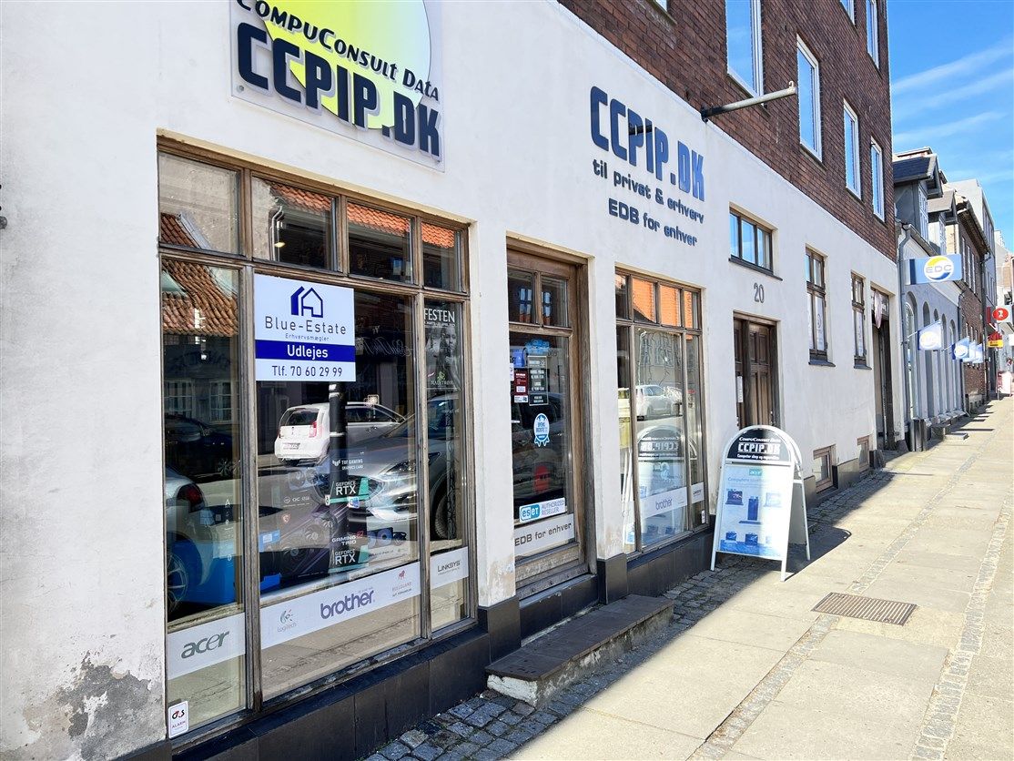 Butik med vinduer og reklameskilt i gaden, der er nummereret 20