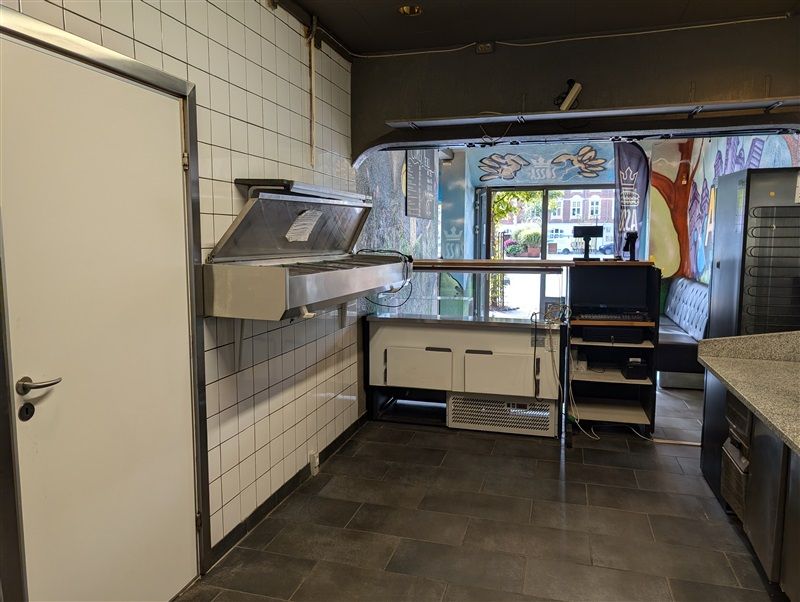 En moderne og veludstyret køkkenafdeling med en stor køleskab, en indbyggede komfur og et kølefelt på væggen.