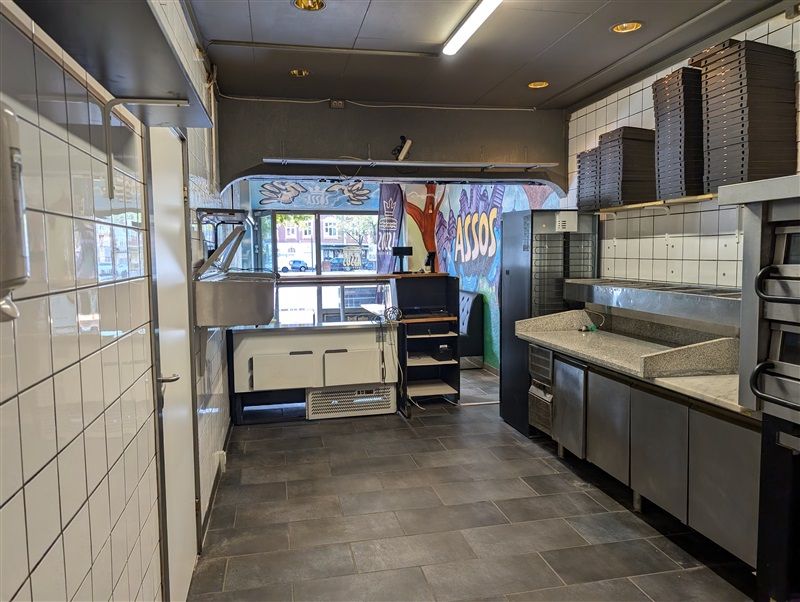 Restaurant med moderne interiør og køkkenudstyr samt lagerrum og salgsdisk med skilte