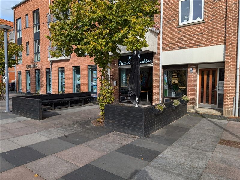 Ledig erhvervslejemål i Fredericia med altaner og plantepots foran restauranten i fredede bygninger