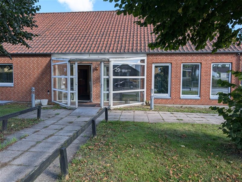 Erhvervsejendom med nummer 29 på Baggrundsvej 29, Ringe. Bygningen er lavet af røde teglsten og har to store glasdøre.