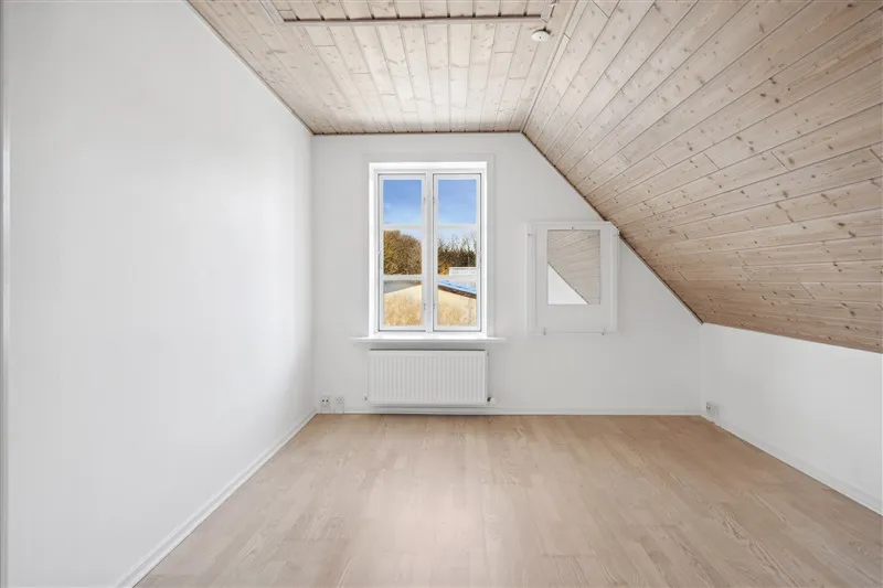 Udlejningsejendom i Farre med hvide vægge og lyse trægulve. Lys og rummelige værelser med lyseglasvinduer og lysekroner.