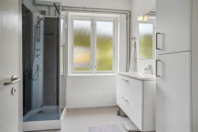 Inden for et rent badeværelse med hvidt bord og spejl samt høj kvalitet badeværelsesudstyret