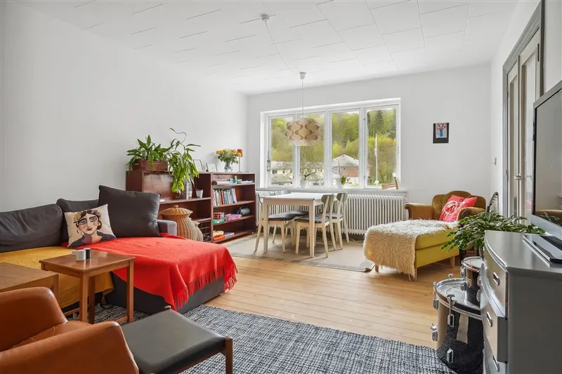 Velholdt lejlighed med lyse, lyse møbler og en stor sofa med puder og tæppe