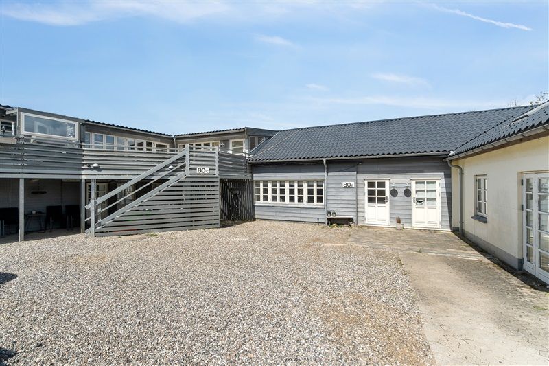 Bygning med nummer 80 og 82 med garage og trapper uden for, gårdhave og glasvinduer