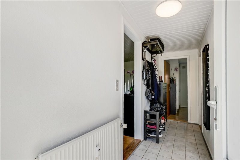 Udlejningsejendom med store vinduer og lys plæneklædt have foran. Møbleret og renoveret med ny radiator i stuen