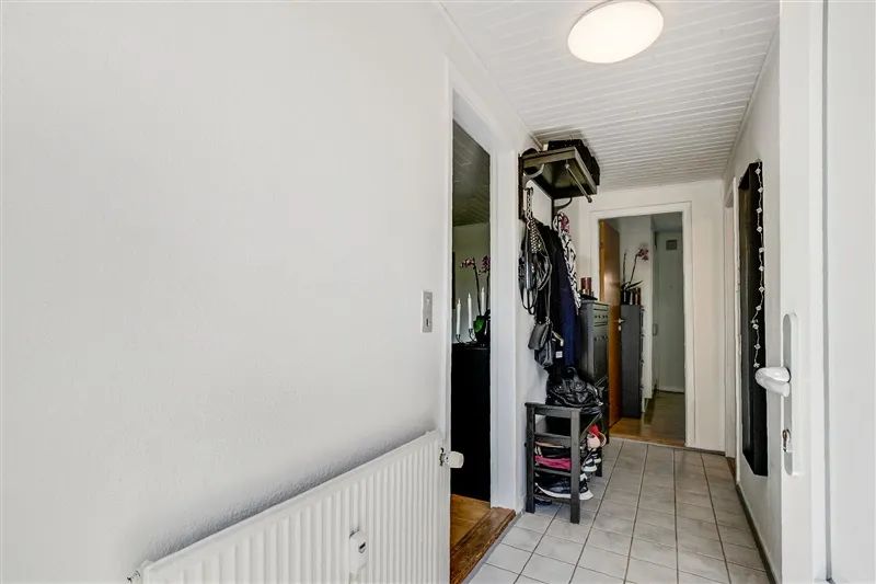 Udlejningsejendom med store vinduer og lys plæneklædt have foran. Møbleret og renoveret med ny radiator i stuen
