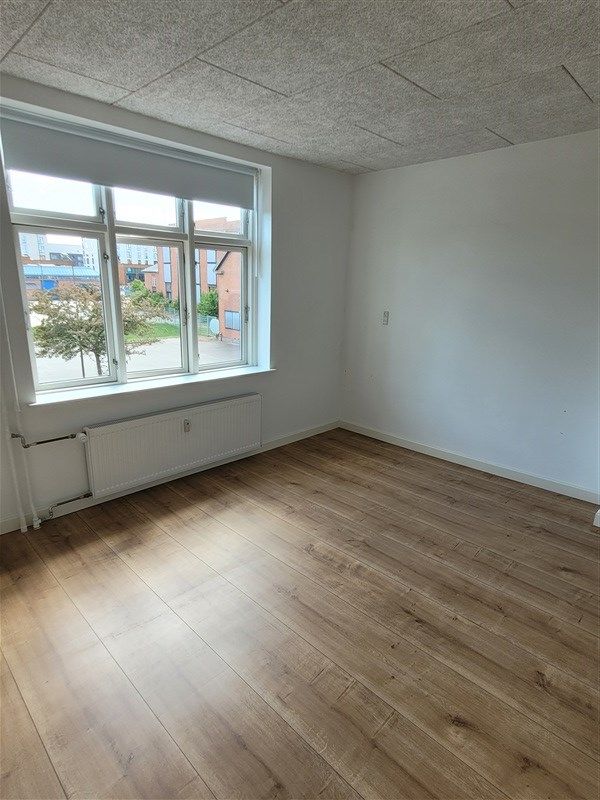 Investeringsejendom med renoveret interiør og trægulv Frederiksgade 97, Fredericia. Vindue med gardiner og solskin i rummet