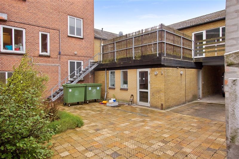 Afkast 6,50% Danmarksgade 21A, 7000 Fredericia Ejer en gårdhave med grønne plantager og 2 større skraldcontainere