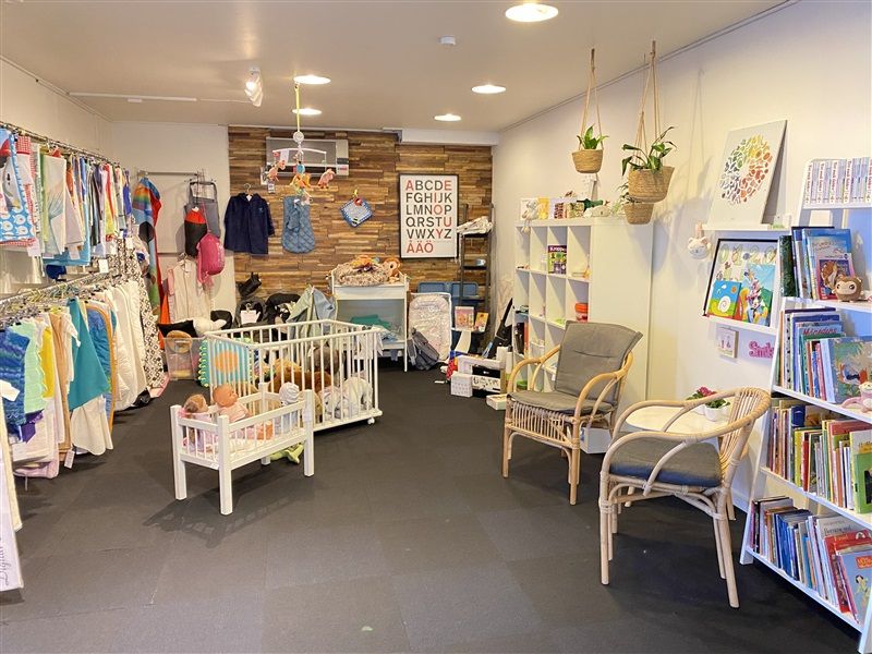 Et møbelforretning med køkken med børnetøj og børnebøger og flere møbler som stole og bord