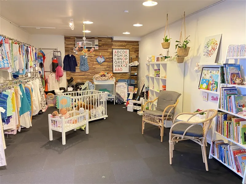 Et møbelforretning med køkken med børnetøj og børnebøger og flere møbler som stole og bord