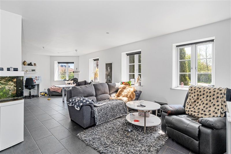 Soveværelse med højt til loftet og hvide vægge med højloftede rum og et stort vinduesparti