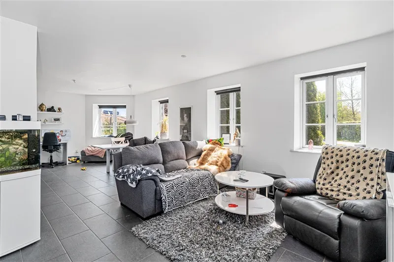 Soveværelse med højt til loftet og hvide vægge med højloftede rum og et stort vinduesparti