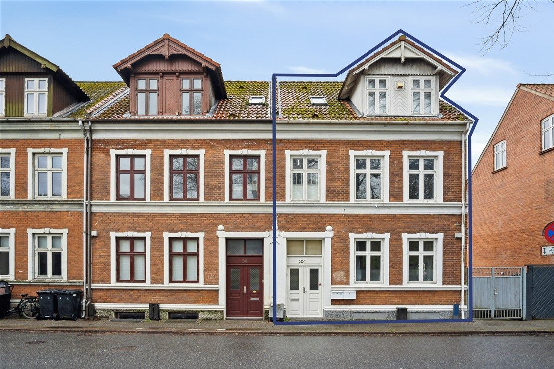 Flot og velholdt udlejningsejendom lige ved voldene i Fredericia med rød mursten og røde tagdækninger