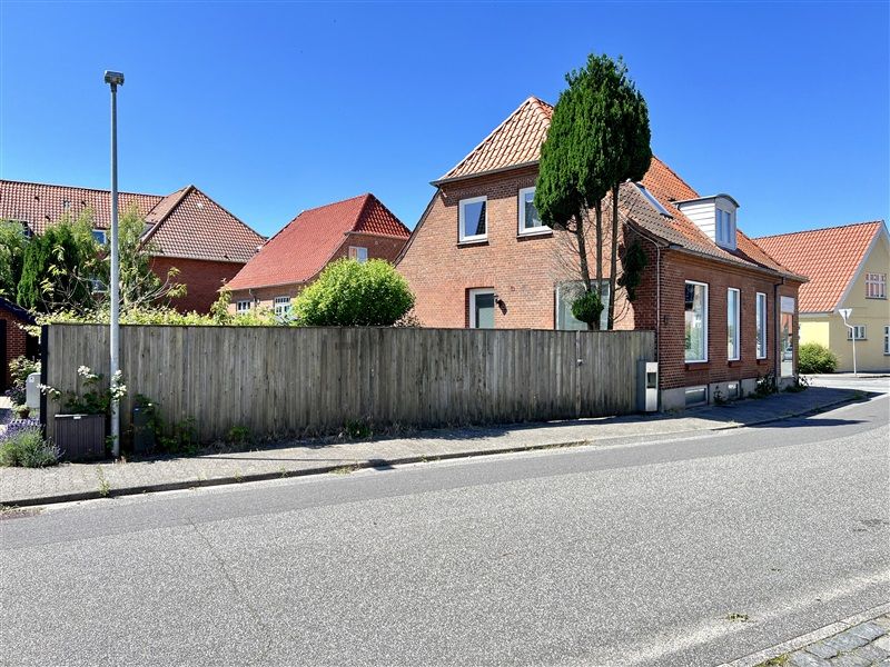 Fredeligt og attraktivt beliggende projekthus med tagsten og træhæk i Fredericia med flere huse i samme stil og en lille