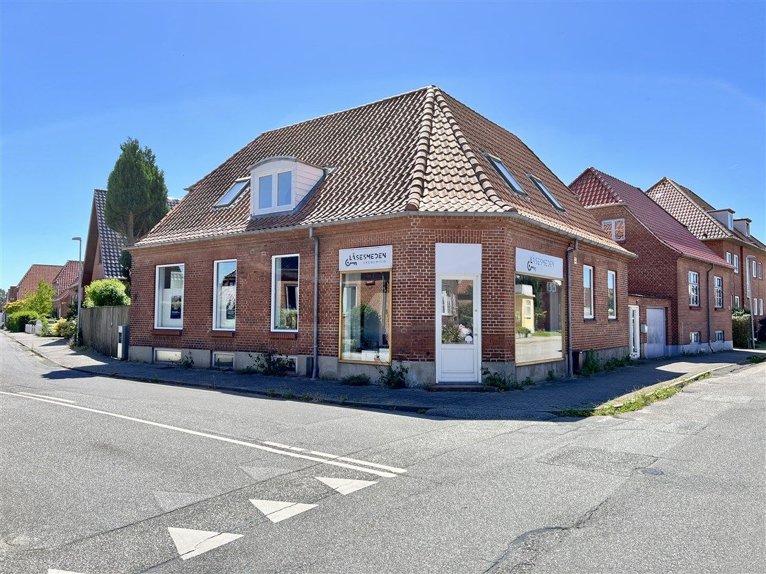 Frederiksen møbelforretning ligger i en smuk bygning med rød tegl og hvide vindueskarme på en stille gade i Fredericia