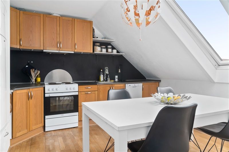 Lille køkken med loftsvinduer, højloft, hvide vægge, moderne køkken med hvid og sort møbler og apparater, høj loftsvinduet