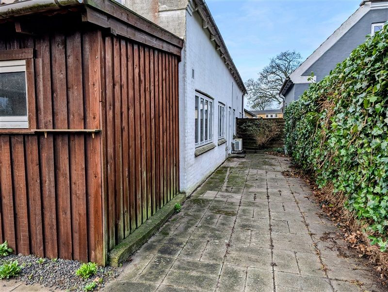 Havepladsvej 50 i Fredericia med et hus med hvid facade og en række vinduer og en lysegrå garage.