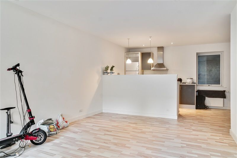 To trægulve er installeret i en lejlighed med hvide vægge og lofter samt lysekroner og en tærskel