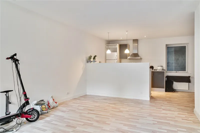 To trægulve er installeret i en lejlighed med hvide vægge og lofter samt lysekroner og en tærskel