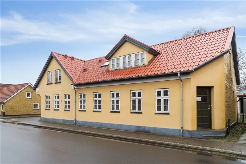 Gult hus med tegltag og hvide ruder ligger på Borgergade 12 i Skovlund, tæt på Ansager, og har 10,06% afkast