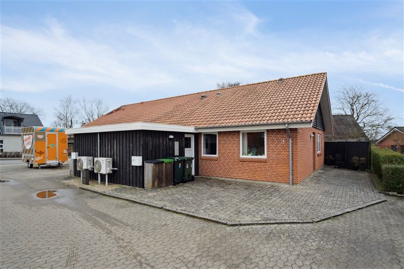 Smukt renoveret rækkehus med garage og skur ved siden af samt have med terrasse og græsplæne