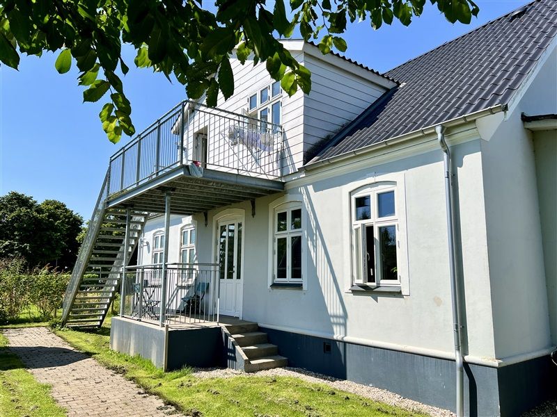 Lejlighedshus med terrasse og skur, 3 lejligheder, møbler og trætrappe på gården, udsigt til grønne områder og træer