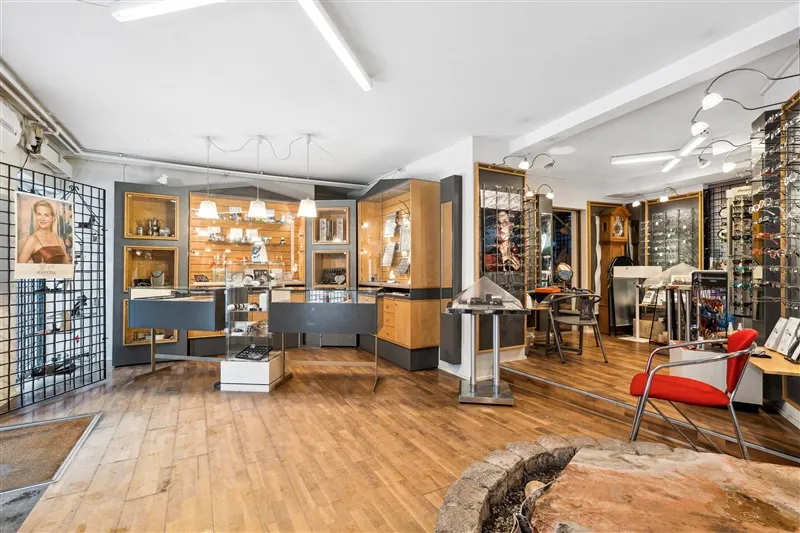 Indenfor udstillingslokaler med stolpe og gulv er der et bord med skuffer og væg med lysekroner