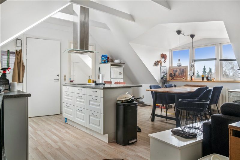 Velholdt stue med højloft, åbent køkken, lysevinduer og moderne møbler for en komfortabel oplevelse