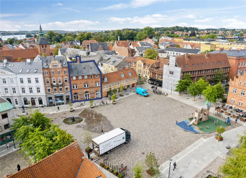 Svendborg torv med et nyt spilområde, en hvid lastbil og en blå lastbil parkeret i nærheden