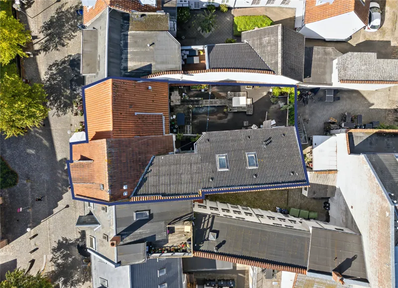 Udlejningsejendom Gerritsgade Svendborg. Et hus med terrasse, garage og have. Parkeret bil og træer i forgrunden