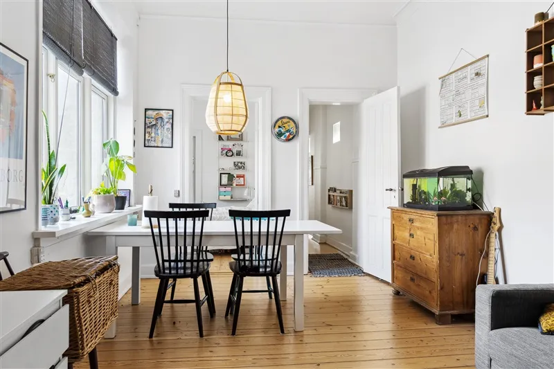 Alt-tekst: Interiør med hvidt spisebord og møbler samt plante og stjerne på væggen