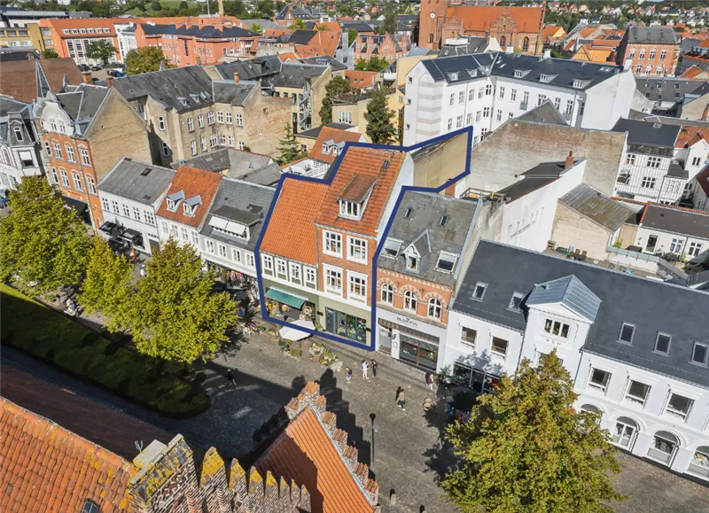 Kort over Svendborg med mange bygninger og grønne træer, forretninger og gader med gående mennesker