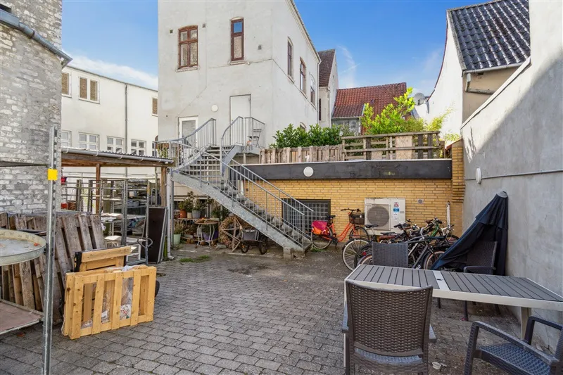 Lejlighed i Svendborg med have, møbler, stige, cykler og teksturer i baggrunden