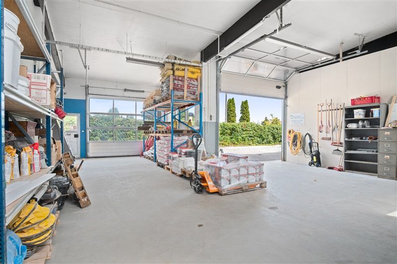 Lager med udstyr og materialer, der inkluderer stel, stiger og andre værktøjer samt flere kasser og beholdere