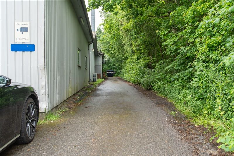 Bilparkeret foran et stort bygningskompleks med skilte med teksten CamVision og Video overvågning.