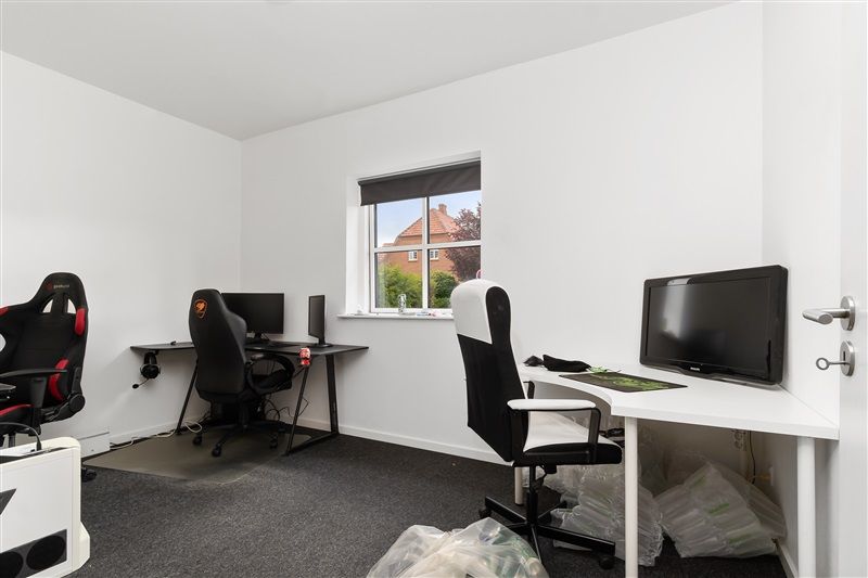 To sorte spilstole med monitorer og en stol med et skrivebord med en stor skærm og et tastatur