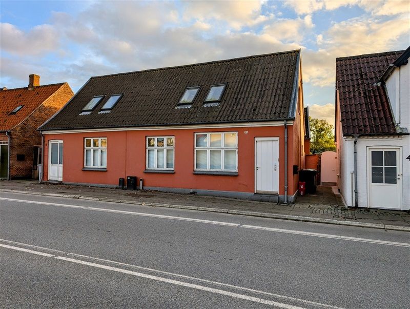 Bygning med røde vægge og sort tag med fire skyvinduer og to hvide døre i Middelfart