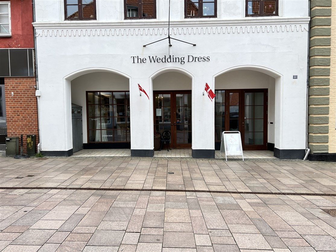 Forretningslokaler til leje i Sønderborg. Forretningshuset ligger i Perlegade 60, med vinduer og døre med tekst, The Wedding
