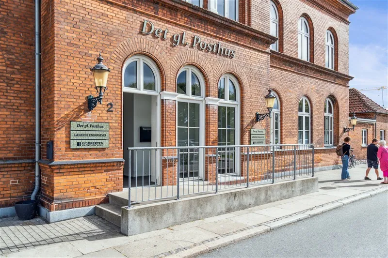 Det gl. Posthus i Nyborg med røde mursten og glasvinduer, lægner og rygsække og kvinder i pink og mænd i sort og hvid