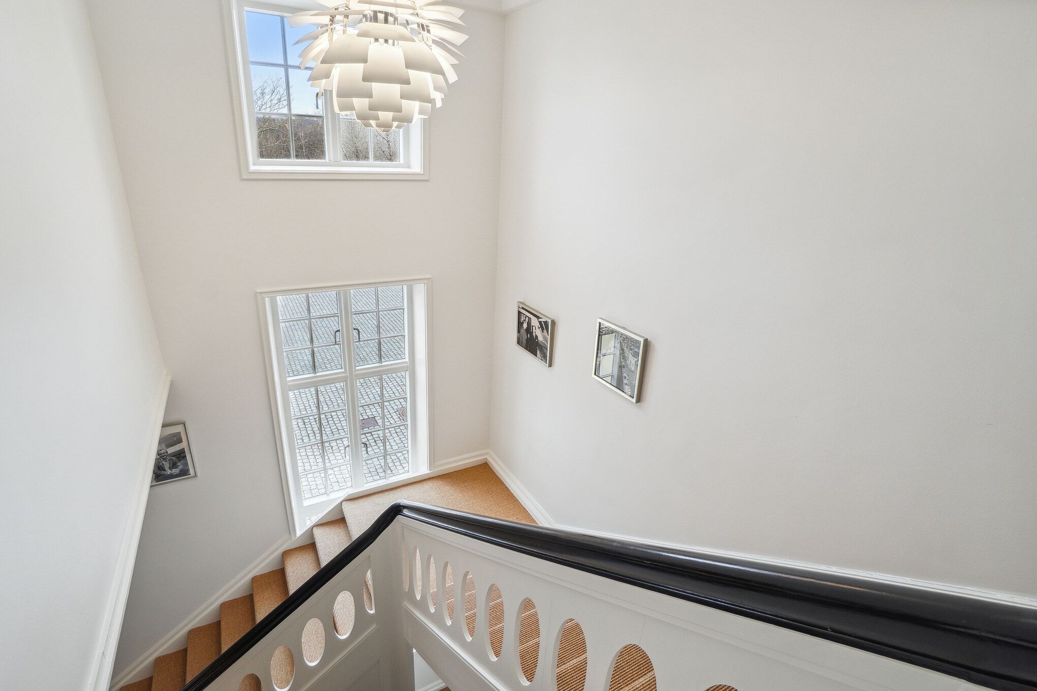 Foto af en luksuriøs og eksklusiv kontorets indgangsparti med lyse loftsvinduer og elegant trætrapper, der fører op til det