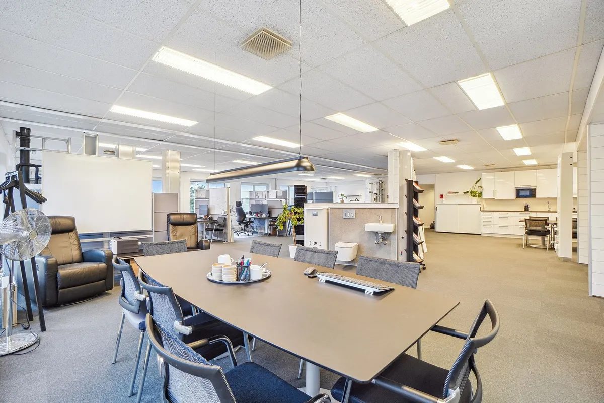 Erhvervslokaler med to sæder og skrivebord, sammen med en sofa, ventilerede lofter og et højt gulv