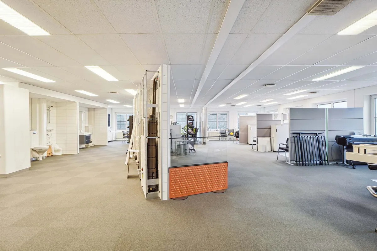 Store kontorlokaler med højt til loftet og møbler til overtagelse, lysegulv og hvide vægge