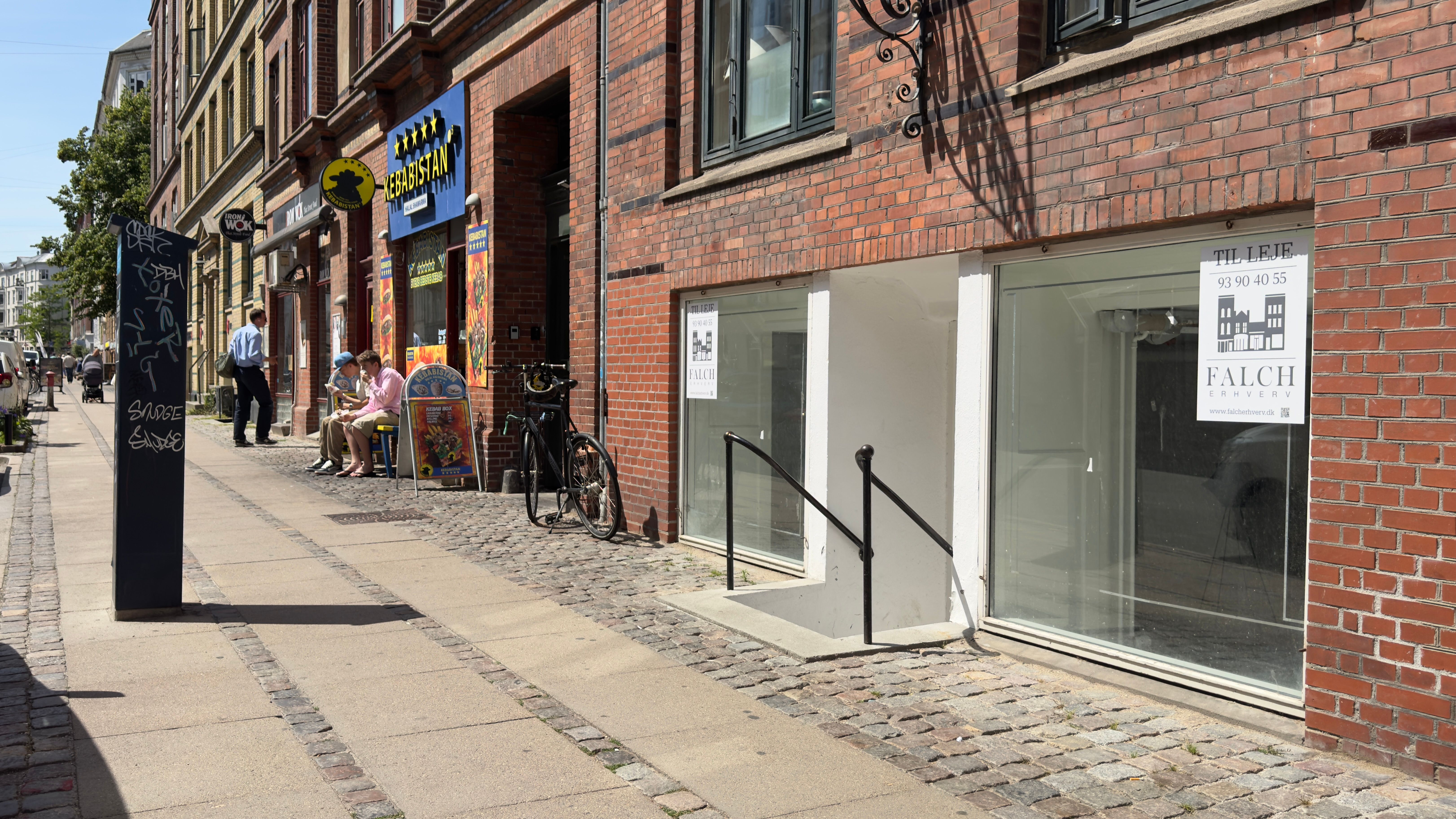 Lejemålet på Nordre Frihavnsgade 65 har store glasruder, hvor man kan se et vindue med metalkonsol og skiltet Falch Erhverv.