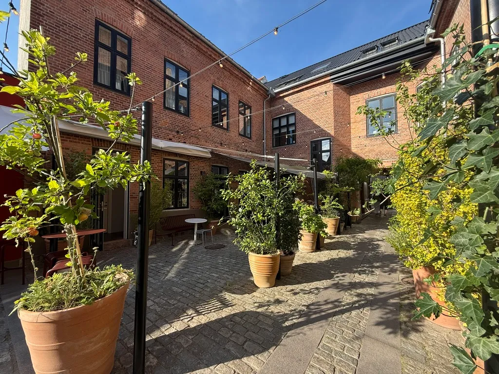 Restaurant med plantager, gulve af pudsede sten og træborde udenfor på Slotsgade 15, 3400 Hillerød