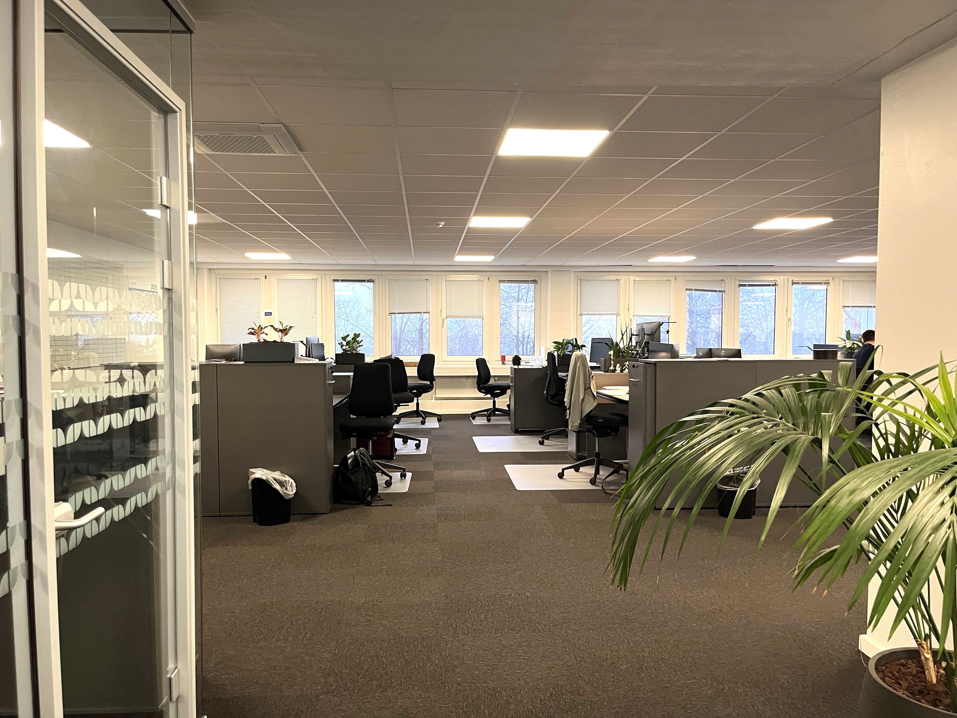 Kontorlejemål med klimaanlæg og lyse lofter, indrettede kontorer med skriveborde, stole og plantager