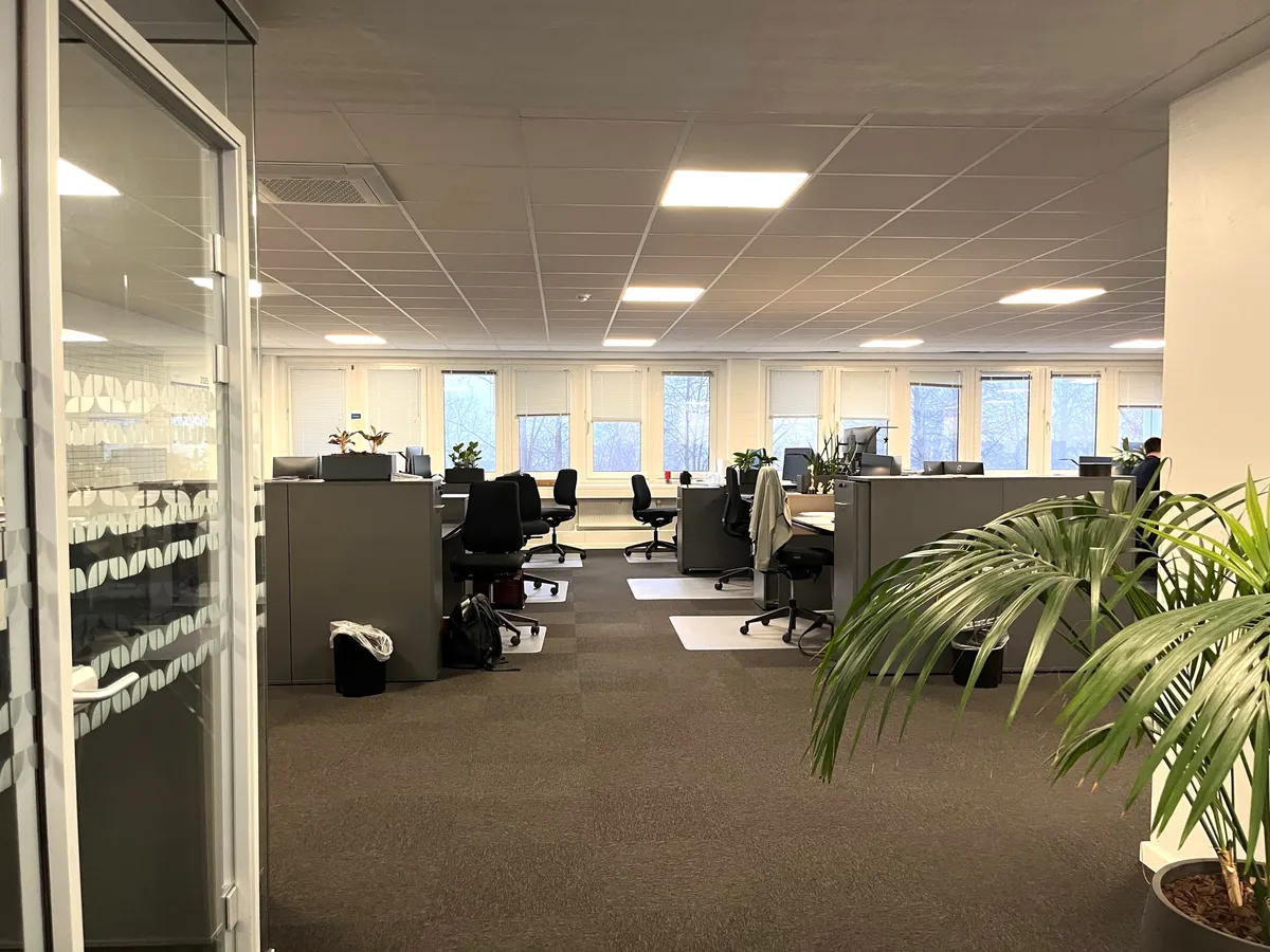Kontorlejemål med klimaanlæg og lyse lofter, indrettede kontorer med skriveborde, stole og plantager